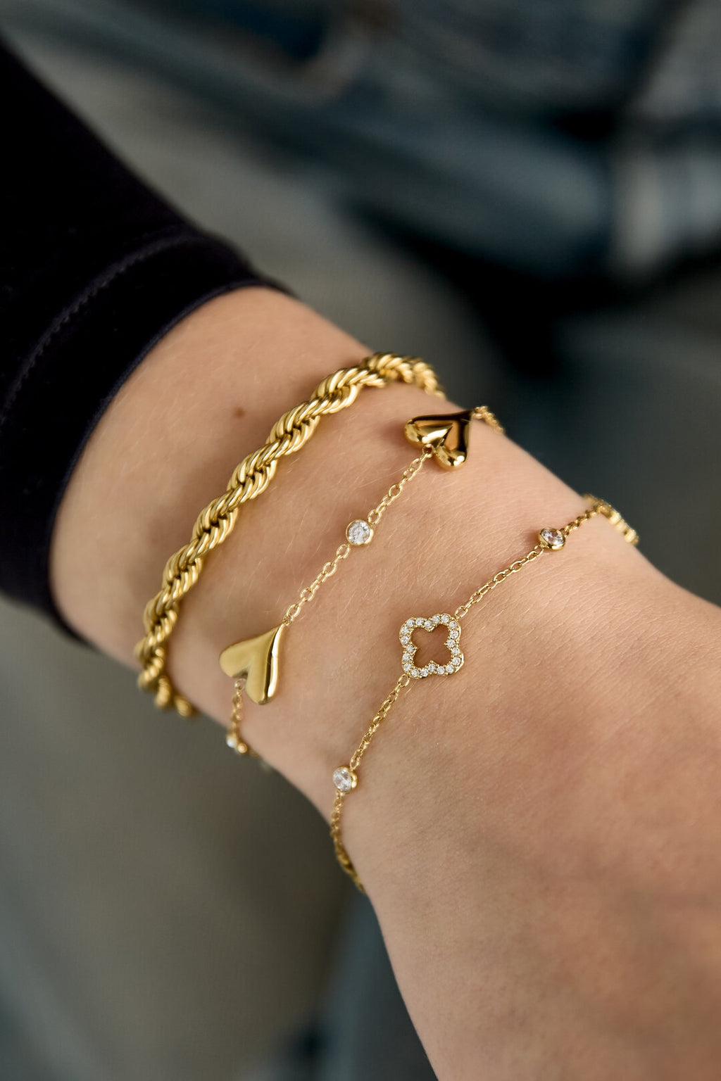 Armband met opengewerkte en belegde klavers en steentjes