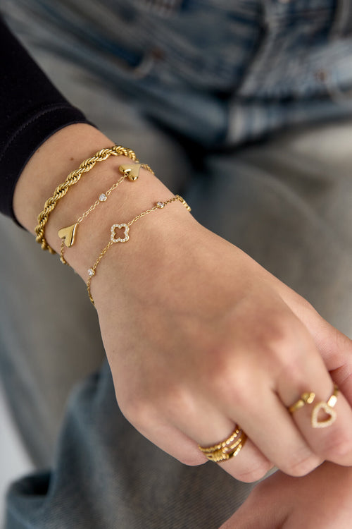 Armband met opengewerkte en belegde klavers en steentjes